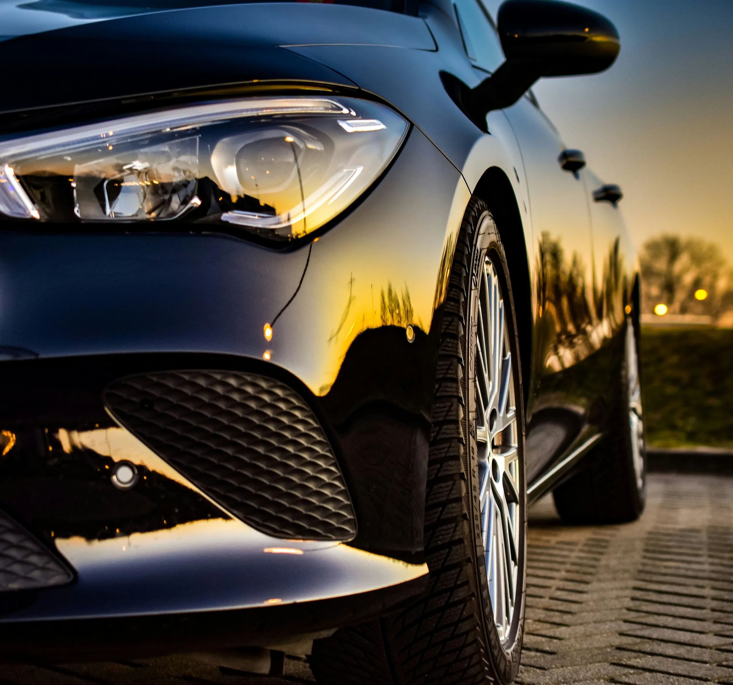 Coche oscuro con pintura pulida al atardecer
